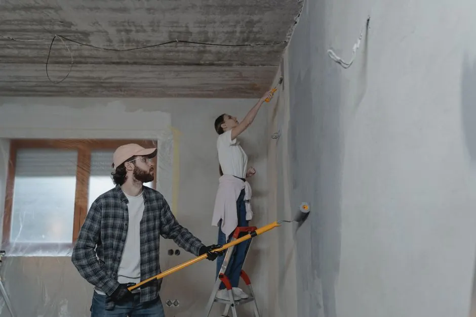 A couple painting a room together, highlighting teamwork in home renovation.